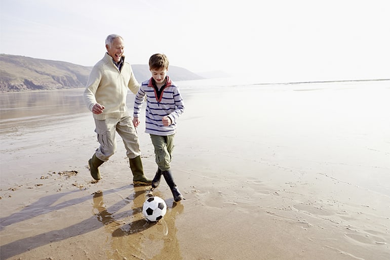 Rentner spielt mit Enkel Fussball am See