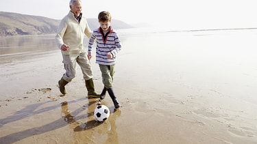 Rentner spielt mit Enkel Fussball am See