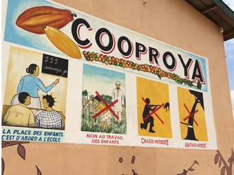 Plakat an einem Gebäude einer Kakaoplantage. Fordert Schulbildung für Kinder, keine Kinderarbeit.